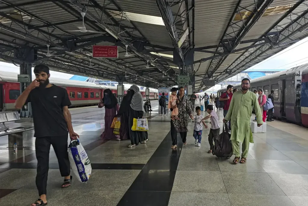 Happy traveler at Indian railway platform representing IRCTC new ticket policy with no cancellation charges and easy rescheduling.