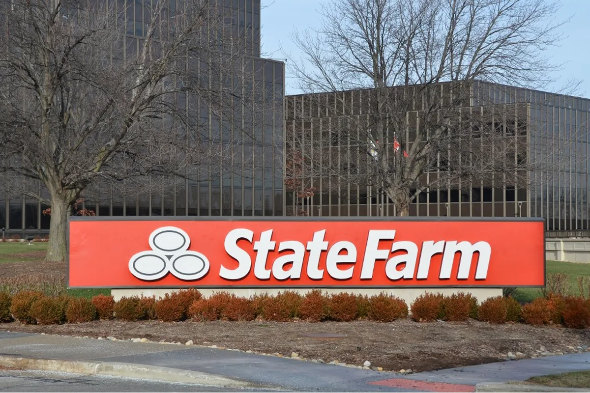 State Farm Insurance agent shaking hands with a Massachusetts homeowner as the company expands its services into the state.