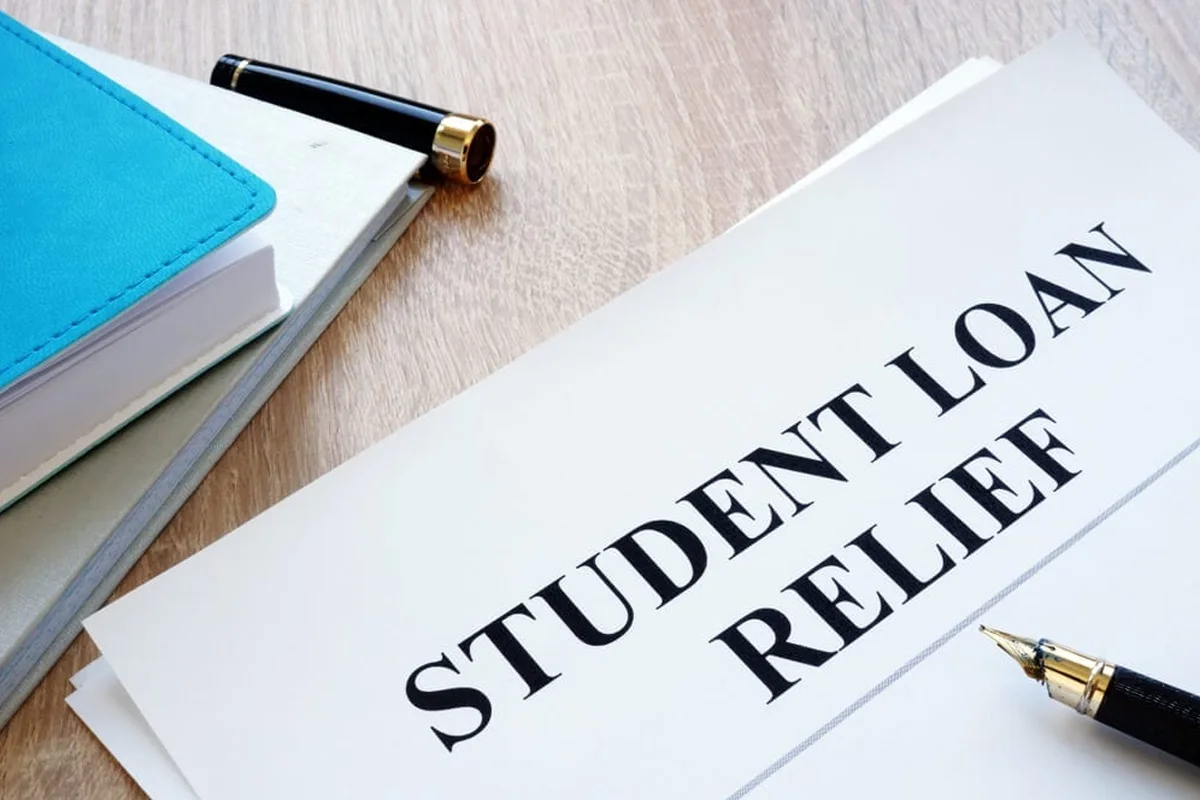 Happy college graduates holding loan documents after the U.S. government introduces a nationwide student loan relief initiative in 2025.