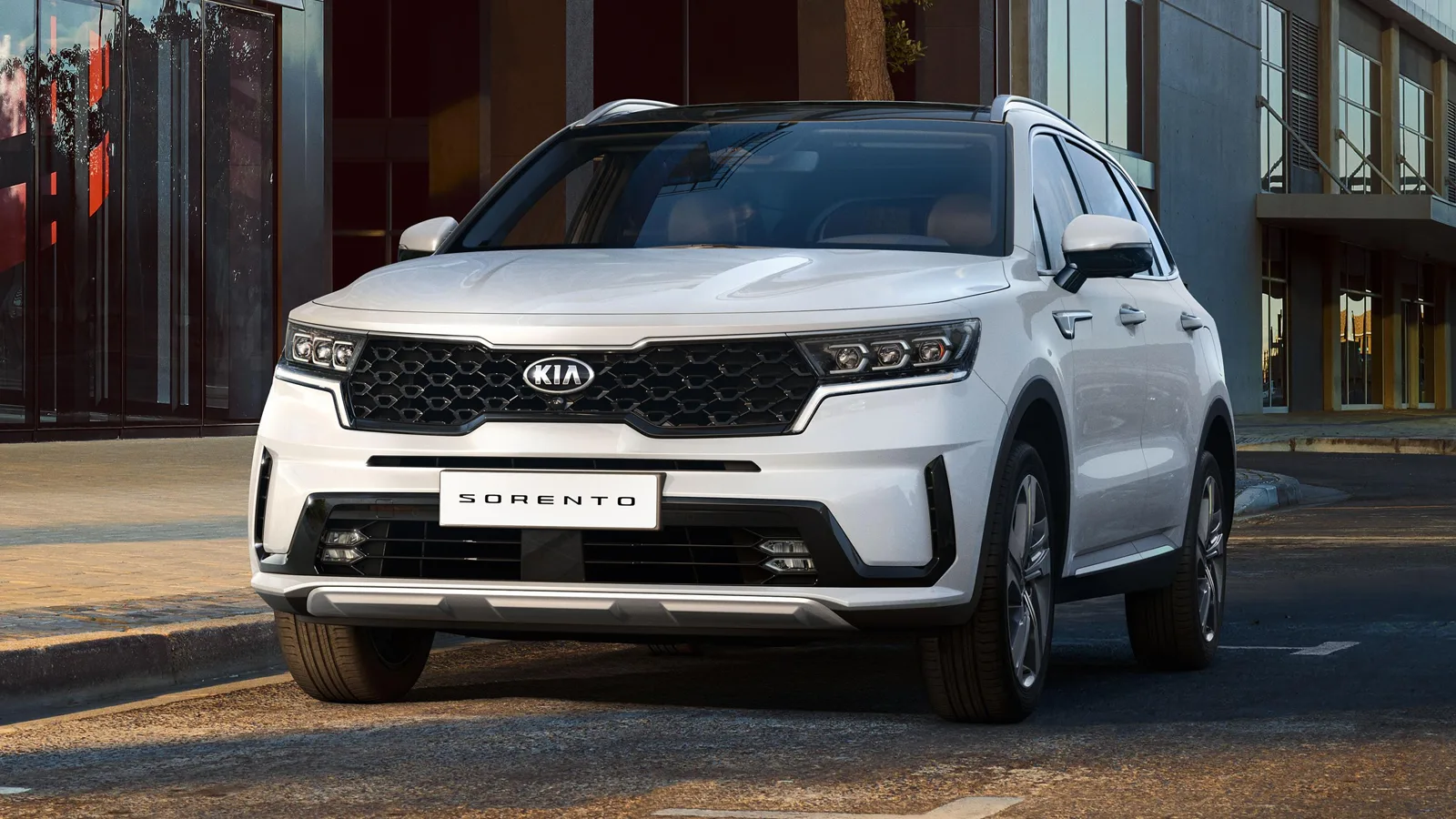 2026 Kia Sorento parked on an open highway, highlighting its updated front grille, LED lights, and strong road presence.