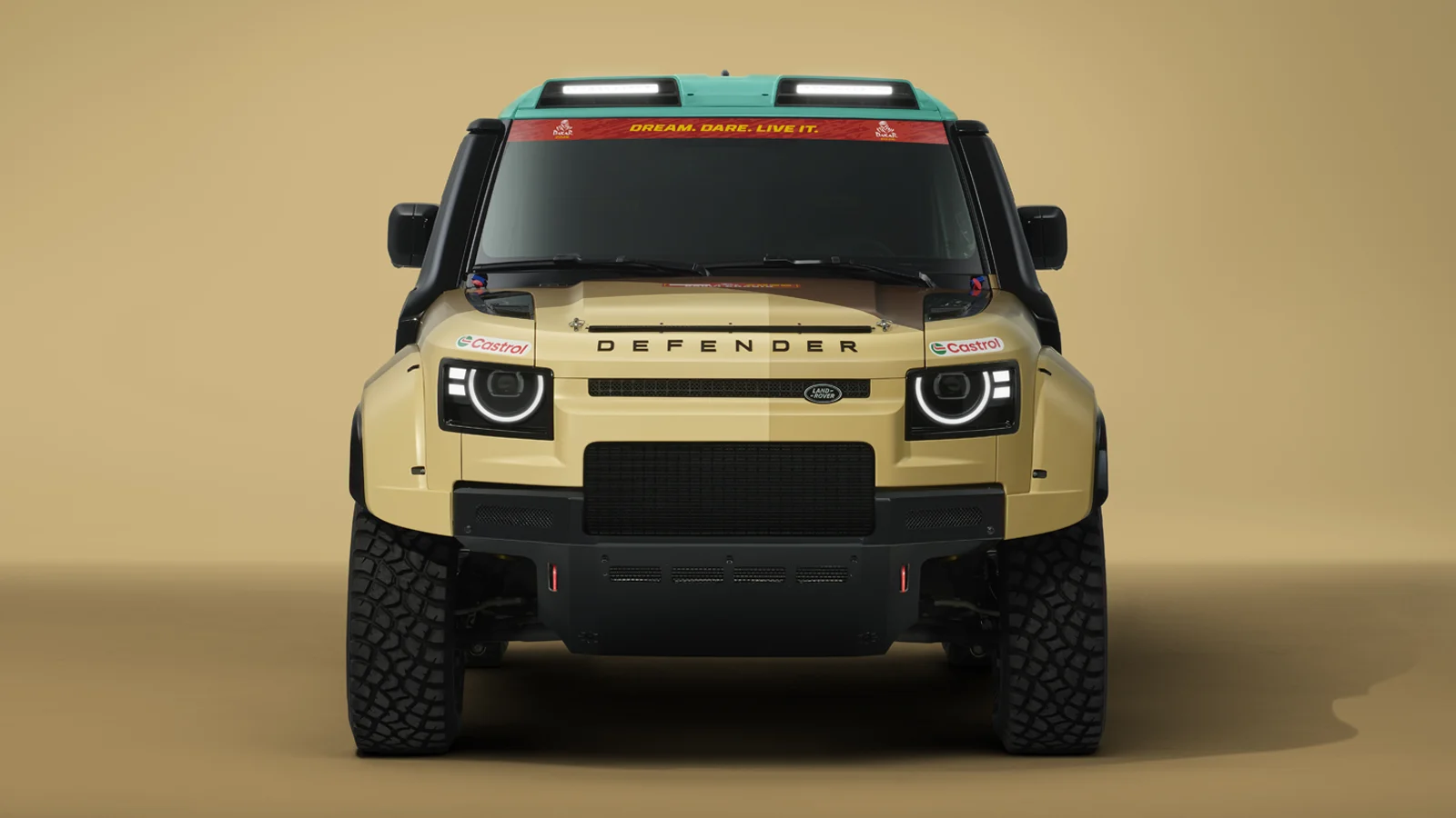 Front view of the Defender Dakar D7x-R in its 2026 Dakar Rally livery, featuring rugged tyres and a bold off-road design.