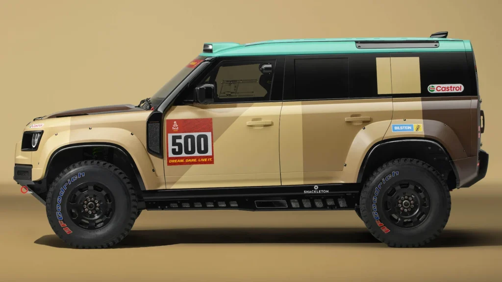 Front view of the Defender Dakar D7x-R in its 2026 Dakar Rally livery, featuring rugged tyres and a bold off-road design.